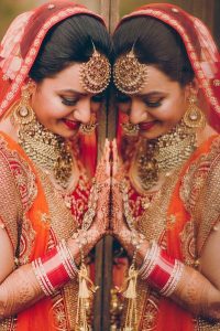 Image That Resembles A Bride Who Poses in Her Wedding Photoshoot infront of the mirror with a Beautiful Smile on her face