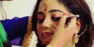 Makeup Artist Assisting The Beautiful Indian Bride.