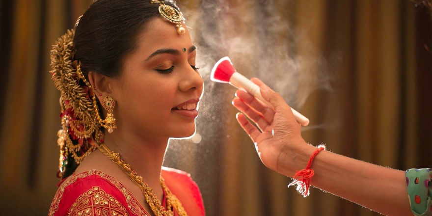 Makeup Artist Doing Final Touch Up At Bride Face During An Indian Traditional Wedding Ceremony.