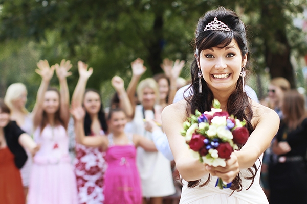 A Smiling Bride Getting Ready To Toss Her Flower Bouqet To Know Which Bridesmaid Will Get Married Next.