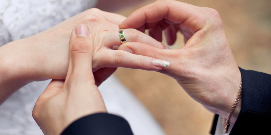 Bride And Groom Exchanging Rings In Their Wedding Ceremony.